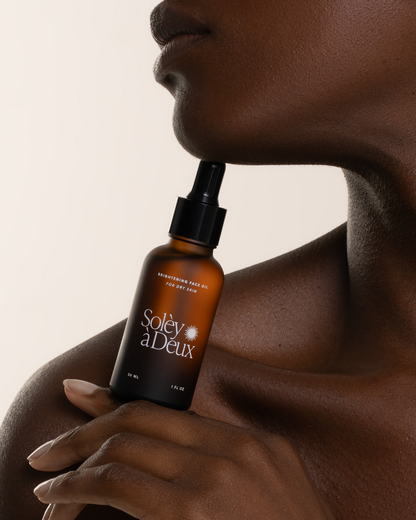 Brightening Face Oil for dry skin held beneath a model's chin