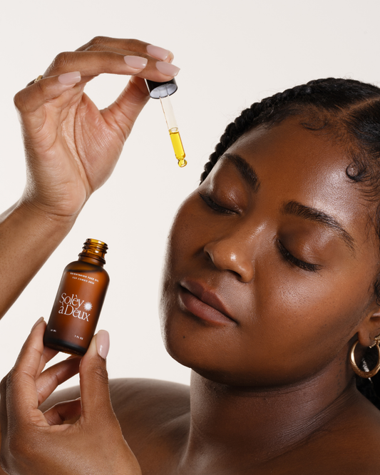 Woman applying Solèy à Deux Brightening Face Oil with a dropper